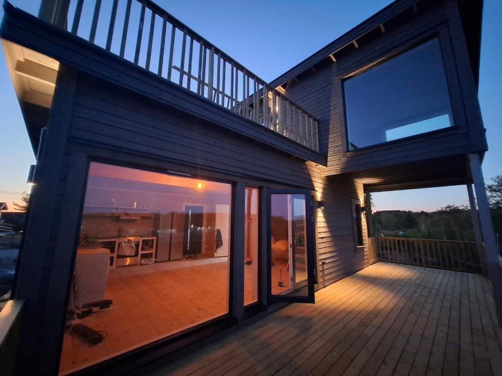 a house with a large deck with glass doors at Newly-built villa in a perfect location! in Grebbestad