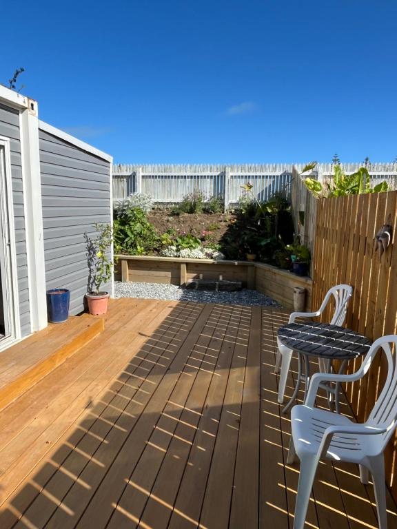 a patio with two chairs and a table on a deck at Centrally located peaceful place in Greymouth