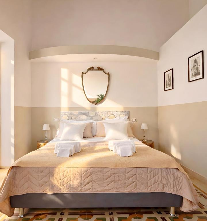 a bedroom with a large bed with a mirror on the wall at Eccelsoleccese Boutique B&B - steps from the Historic Center in Lecce