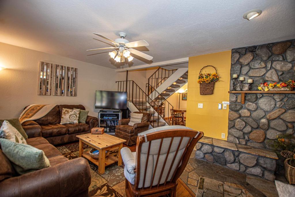 a living room with a couch and a stone wall at Lake Forest Glen # 142 in Tahoe City