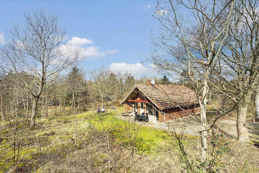 a log cabin in the middle of a forest at 113-Ringkobing-Ahornalle-16 in Nørby