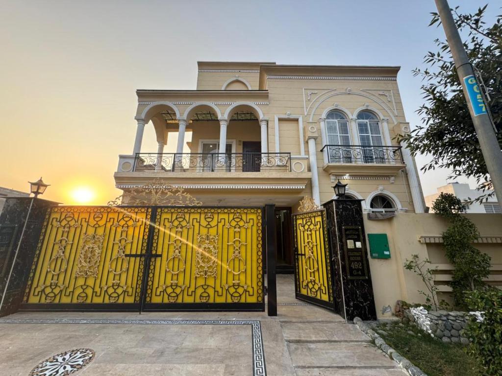a house with a yellow gate in front of it at 6-BedRoom house in Bahria in Lahore