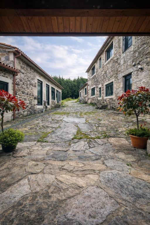 an empty stone road between two stone buildings at Casa Bolboreta by Unusual Hotels in Palas de Rei