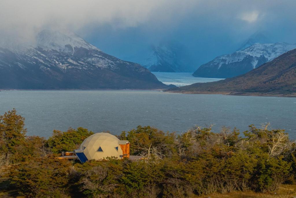 a tent on the side of a lake with mountains at Estancia Patagonia El Calafate - Pristine Luxury Camps in El Calafate