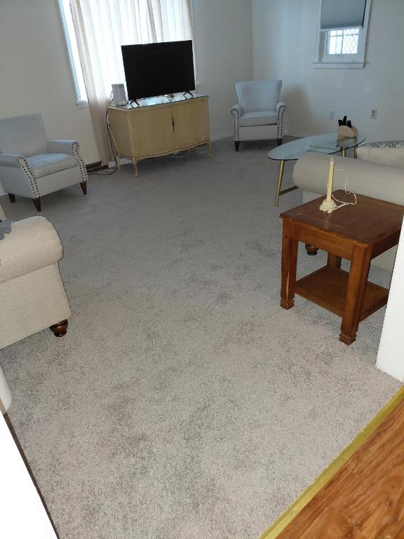 a living room with couches and a table and a tv at Quiet Harrisburg home in Harrisburg