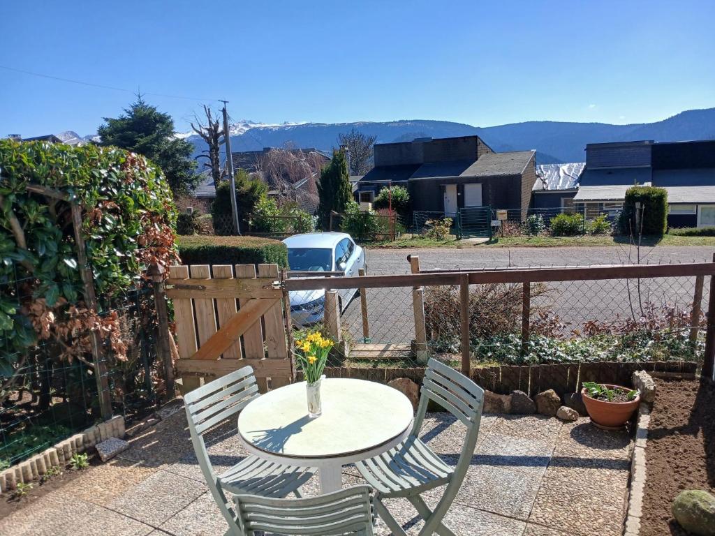 a table with a vase of flowers on a patio at Maison 2-4 personnes, vue sur le Sancy in Murat-le-Quaire