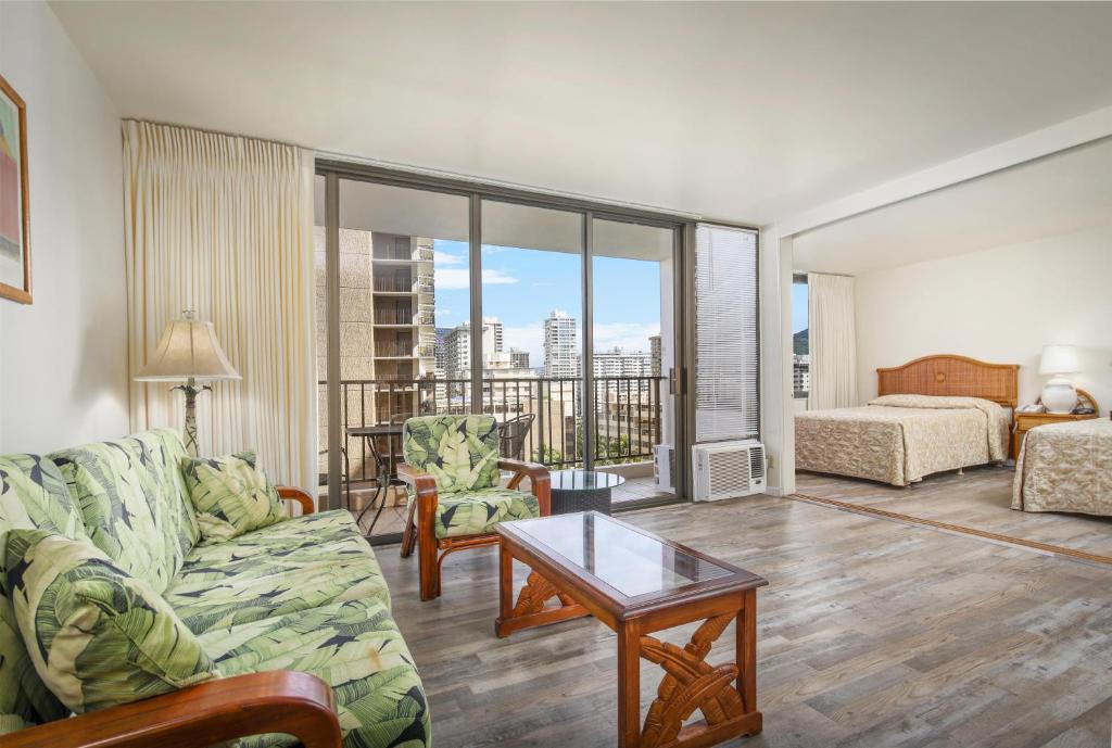 a living room with a couch and a table at Aston at the Waikiki Banyan in Honolulu