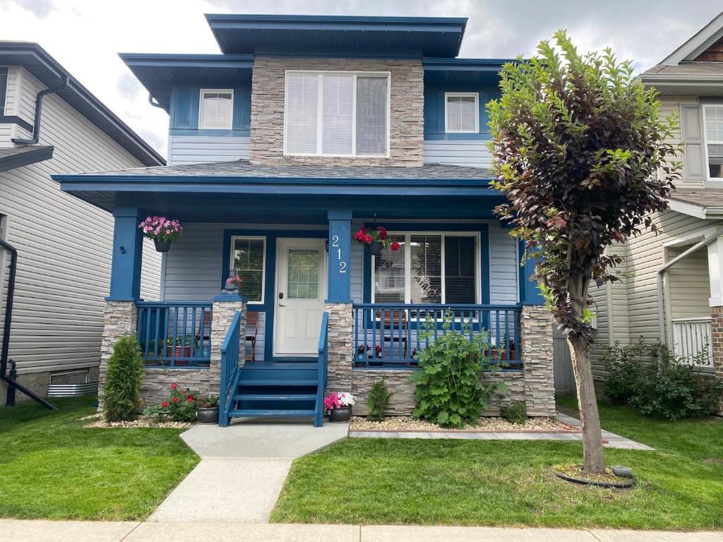 a blue house with a blue door and a tree at Blue Kuti B&B in Edmonton