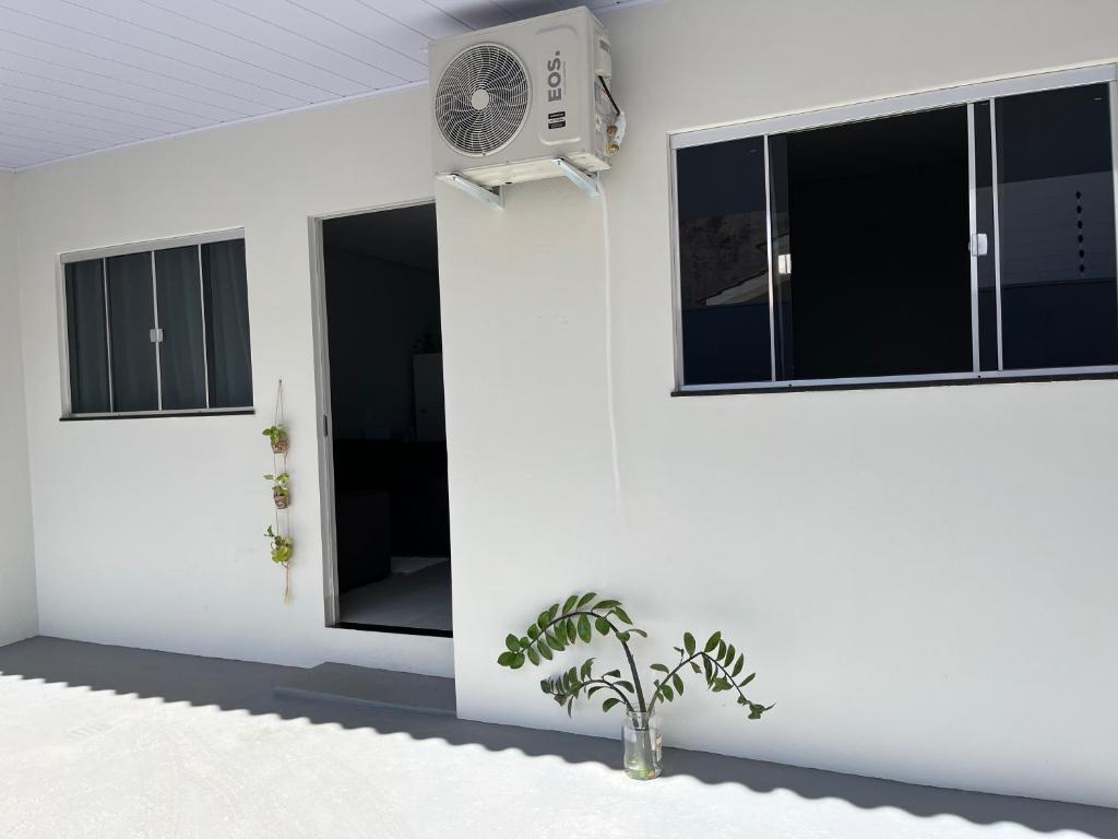 a white wall with a window and a fan at Residenc Mazonetto in Primavera do Leste