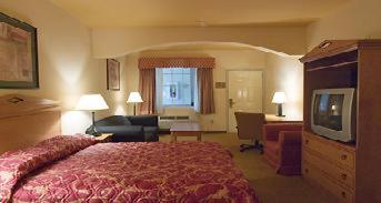 a hotel room with a large bed and a living room at Garden Inn Hotel in Union City