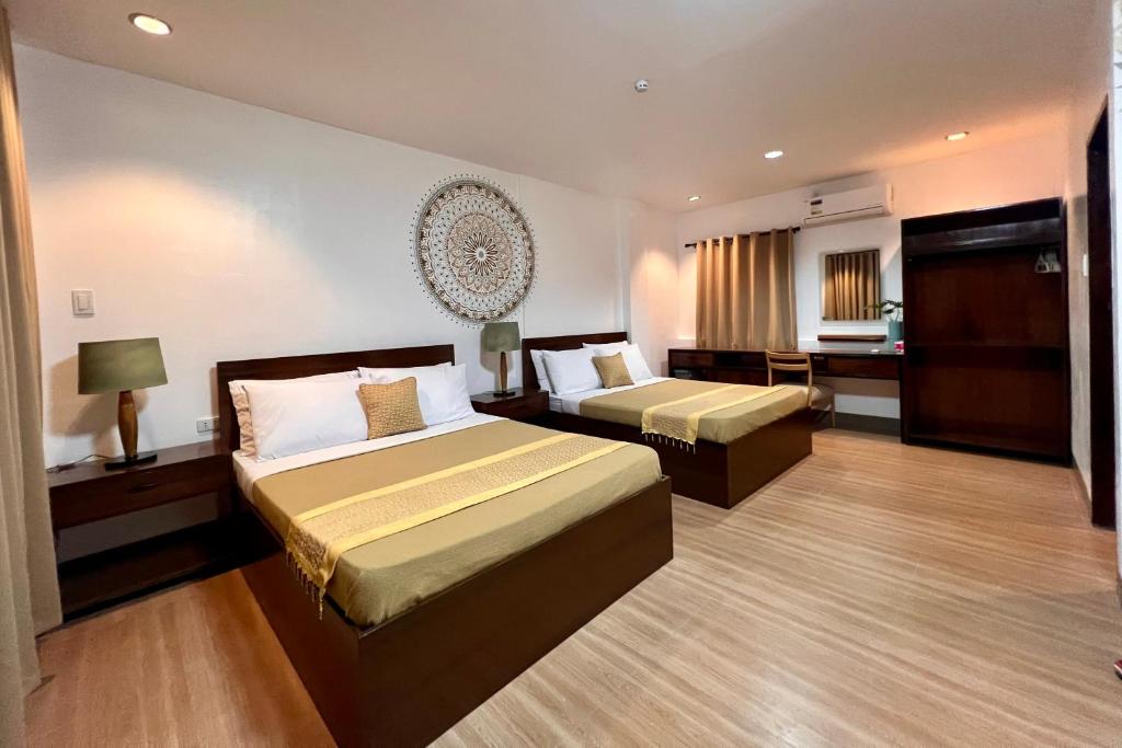 a hotel room with two beds and a desk at OHANA Homestay in Coron