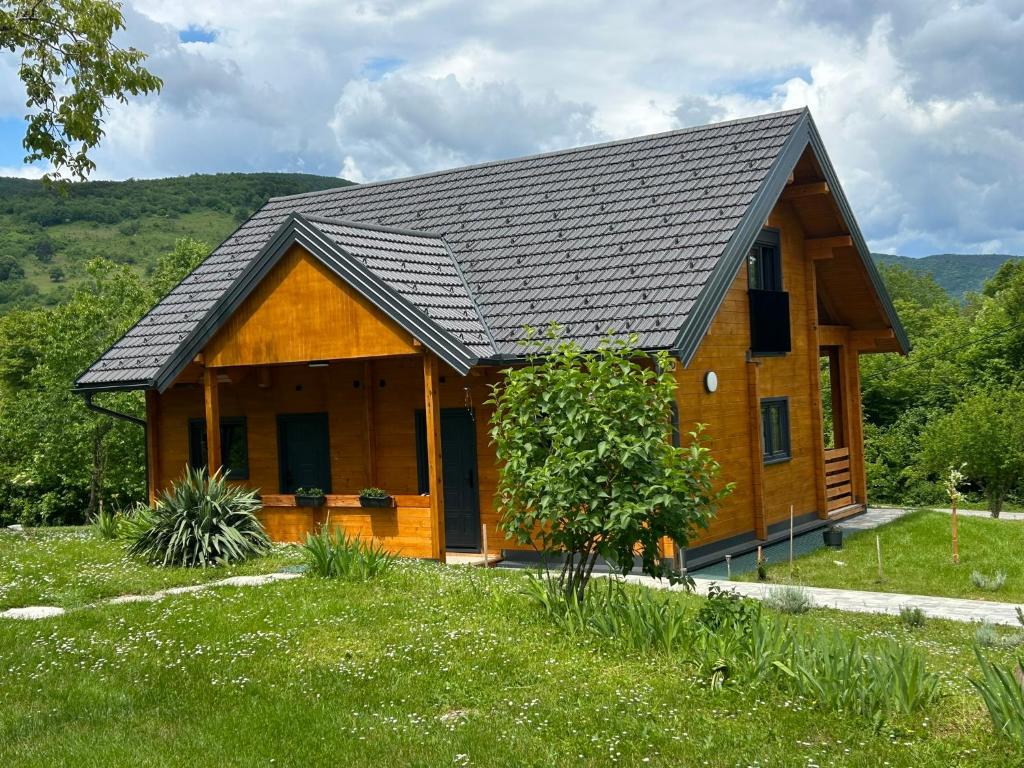 a wooden house with a black roof at Wooden Villa Old Oak Plitvice Lakes in Seliste Dreznicko