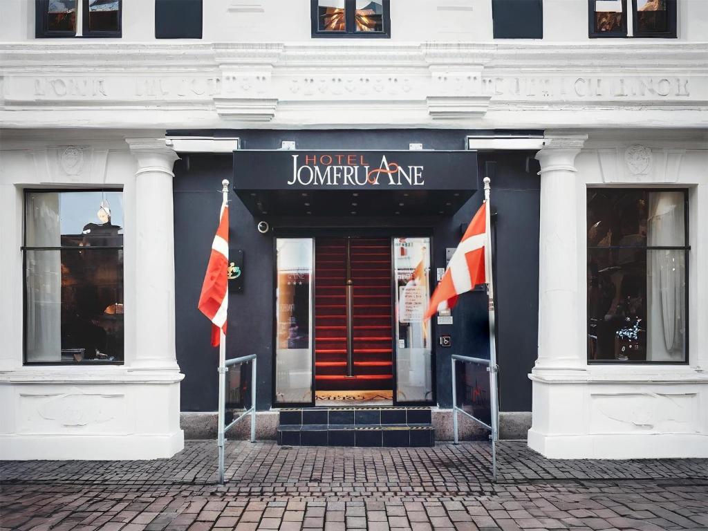a building with two flags in front of it at Dancenter Hotel Jomfru Ane Standard Double in Aalborg