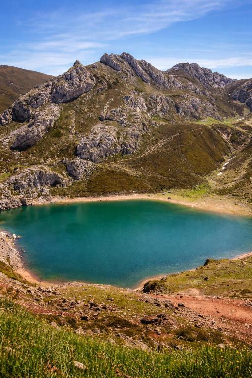 a large blue lake in the middle of a mountain at Coronel Somiedo by Unusual Hotels in El Puerto de Somiedo