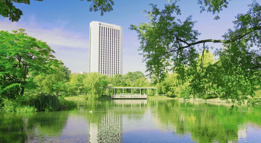 a view of a building from a park with a pond at Premier Hotel Nakajima Park Sapporo in Sapporo