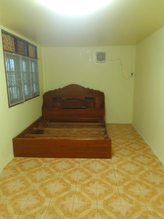 a bedroom with a wooden bed in a room at รีสอดเวล์ in Samutprakarn