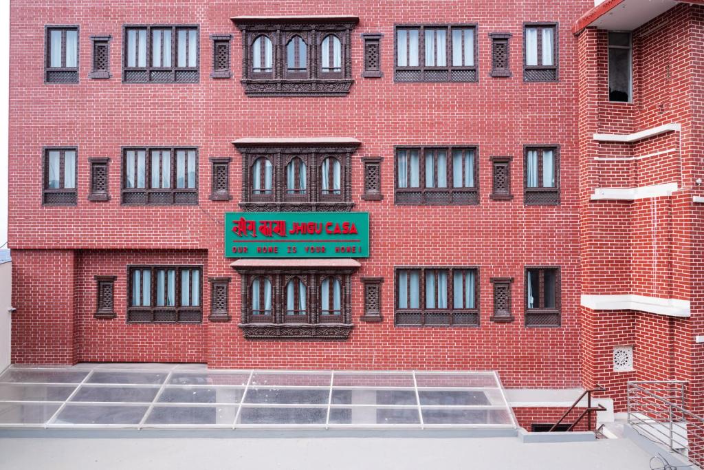 a red brick building with a sign on it at Jhigu Casa Homestay in Kirtipur