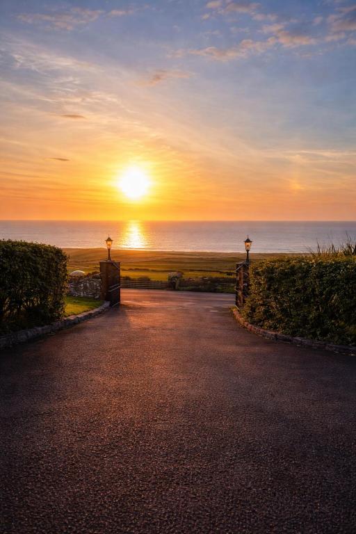 an empty road with the sunset in the background at Aran View Holiday Homes - The Courtyard Suite - Cozy for two in Doolin