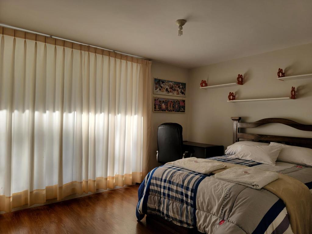 a bedroom with a bed and a window with curtains at Hospedaje Campestre María Eugenia in Cajamarca