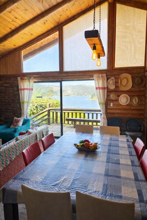 a dining room with a table and chairs and a large window at Casa Amanecer Vichuquén in Vichuquén Lake