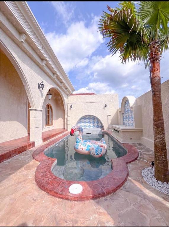 a swimming pool with an inflatable animal in a building at Princessa Villa by Raminten in Pakem