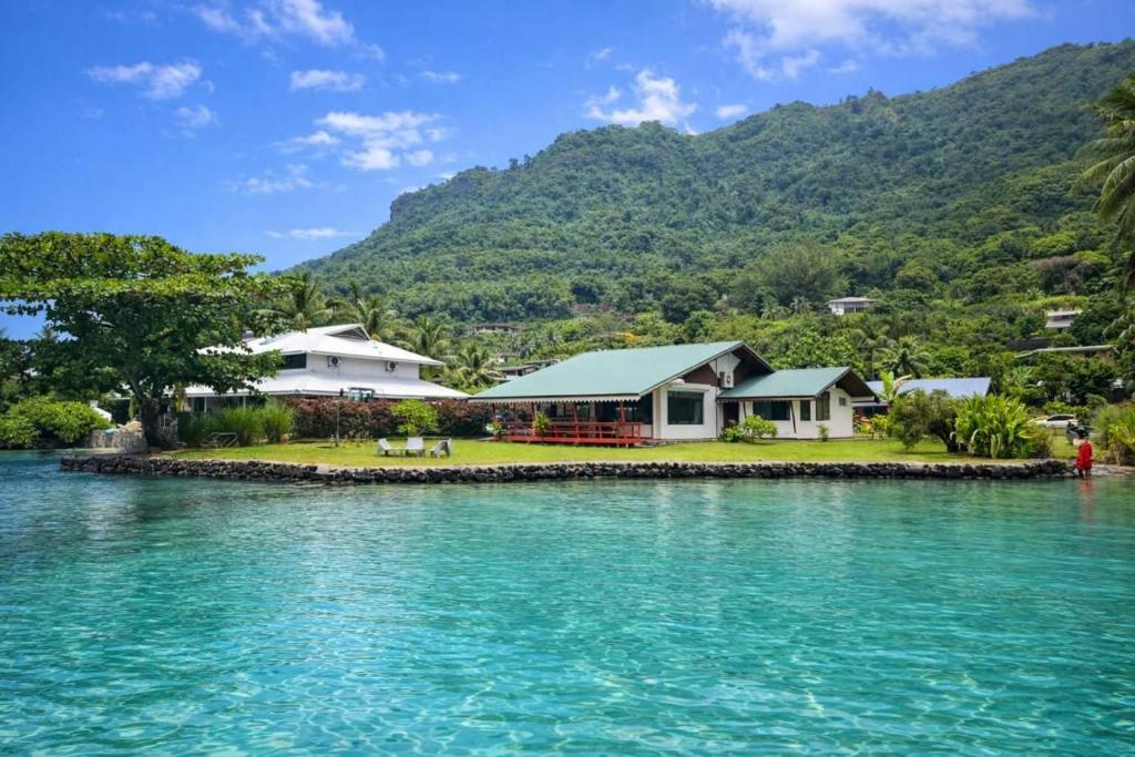 a house on a small island in the water at FaraTea Bay house in Paopao