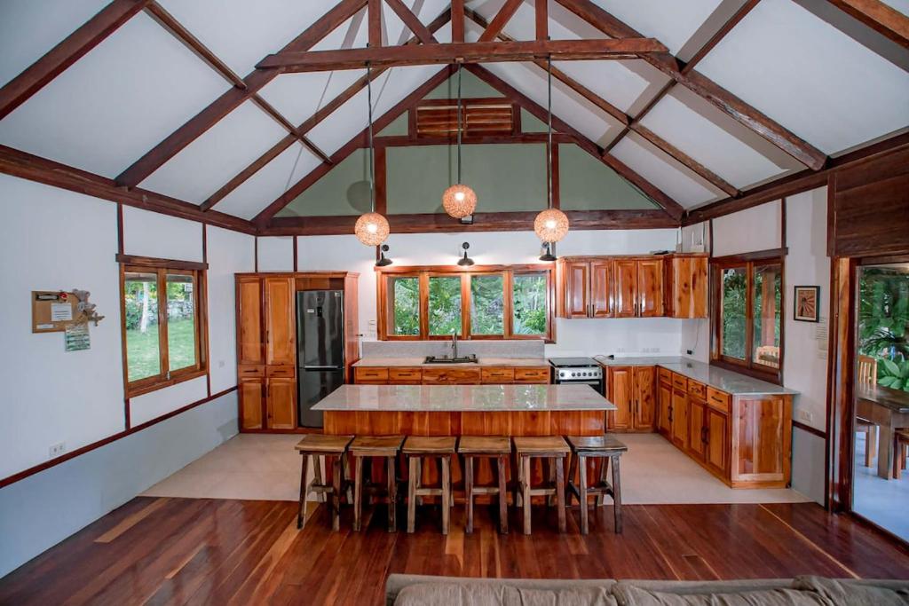 a large kitchen with wooden cabinets and a large ceiling at Eco-Villa Camiguin in Mambajao