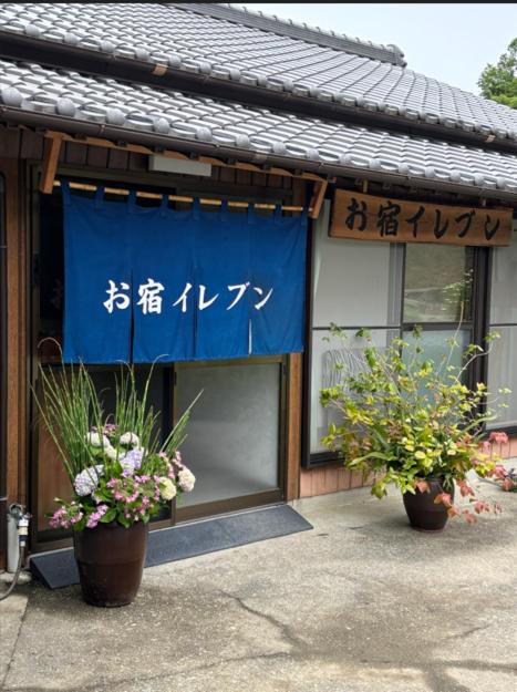 a building with two potted plants in front of it at お宿イレブン in Yoshinogawa