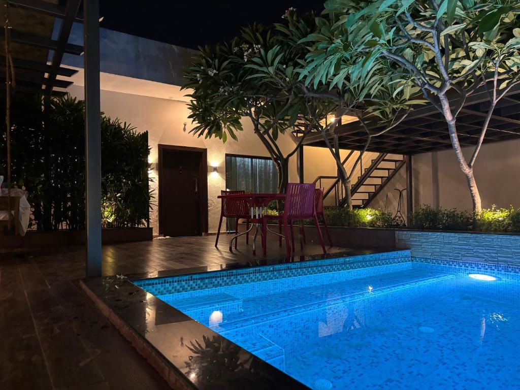 a swimming pool in a backyard with a table and chairs at Lumbini in Varanasi
