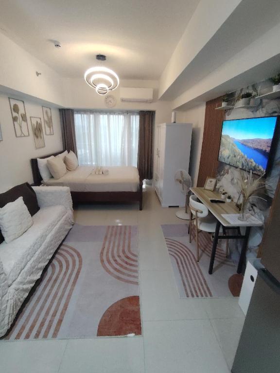 a living room with a couch and a bed at Spacious Studio Davao in Davao City