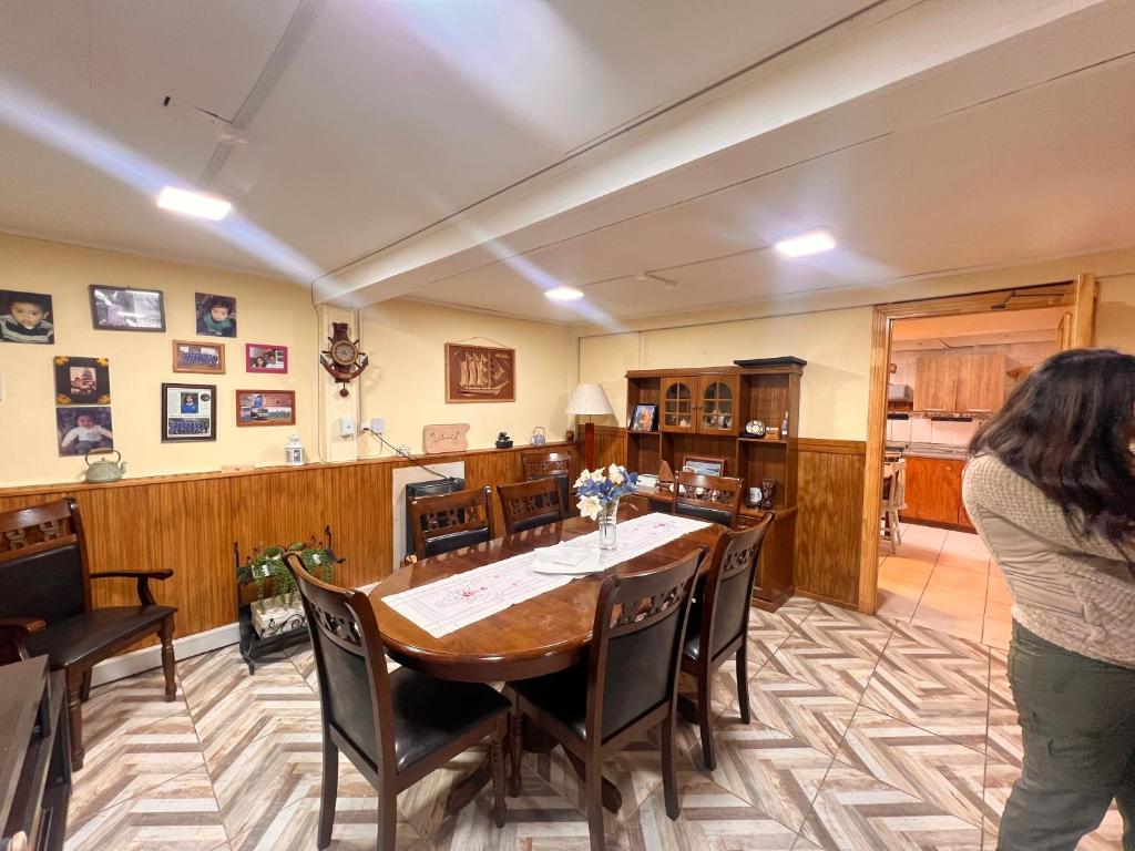 a woman standing in a room with a table and chairs at Morada Austral in Punta Arenas