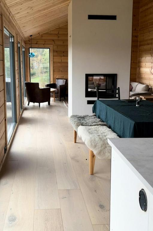 a bedroom with a bed and a living room with a piano at Architect-Designed Log Cabin By Myllavannet in Lunner