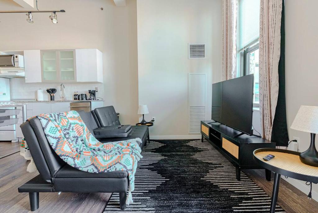 a living room with two chairs and a flat screen tv at The City Escape| Studio Apt w/ Skyline Views in Cincinnati