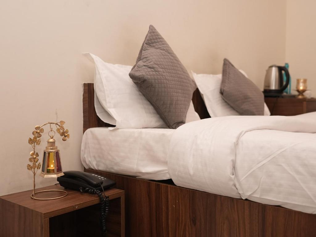 a bedroom with two beds with white sheets and pillows at Life Tree Hotel and Banquet Hall, Sector 63A in Noida