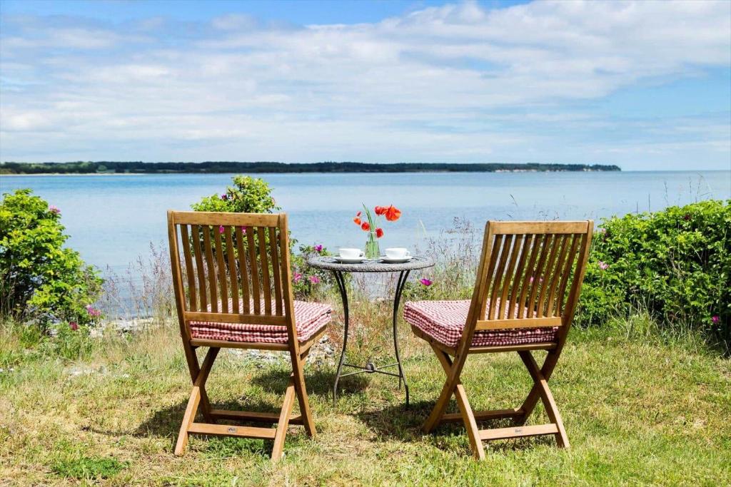 two chairs and a table in front of a lake at 40155-Juelsminde-Bugten-31 in Juelsminde