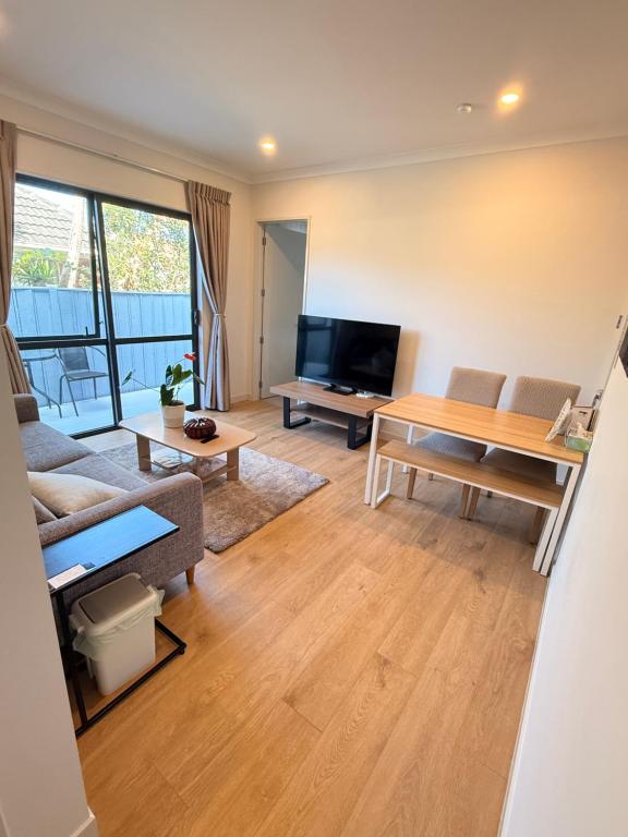 a living room with a couch and a table at Modern Private 2BR Unit in Takapuna in Auckland