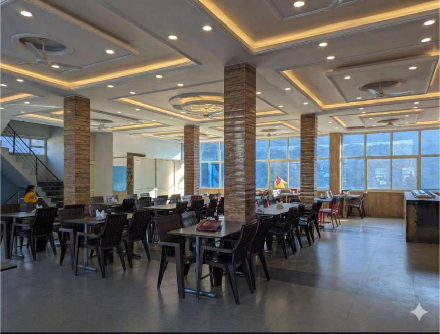 a dining room with tables and chairs and windows at Silver oak Hotel and Restaurant in Pāndoh