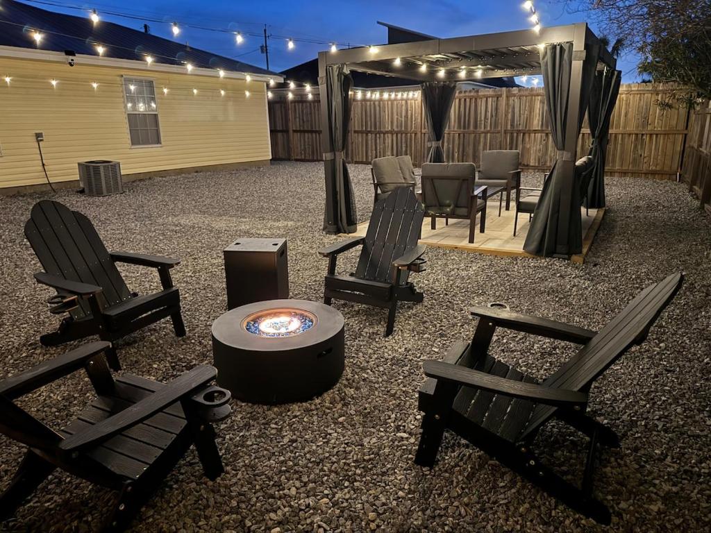 a patio with chairs and a table and a grill at Sunset Beachside Getaway, 6 mins WALK to the Beach in Panama City Beach