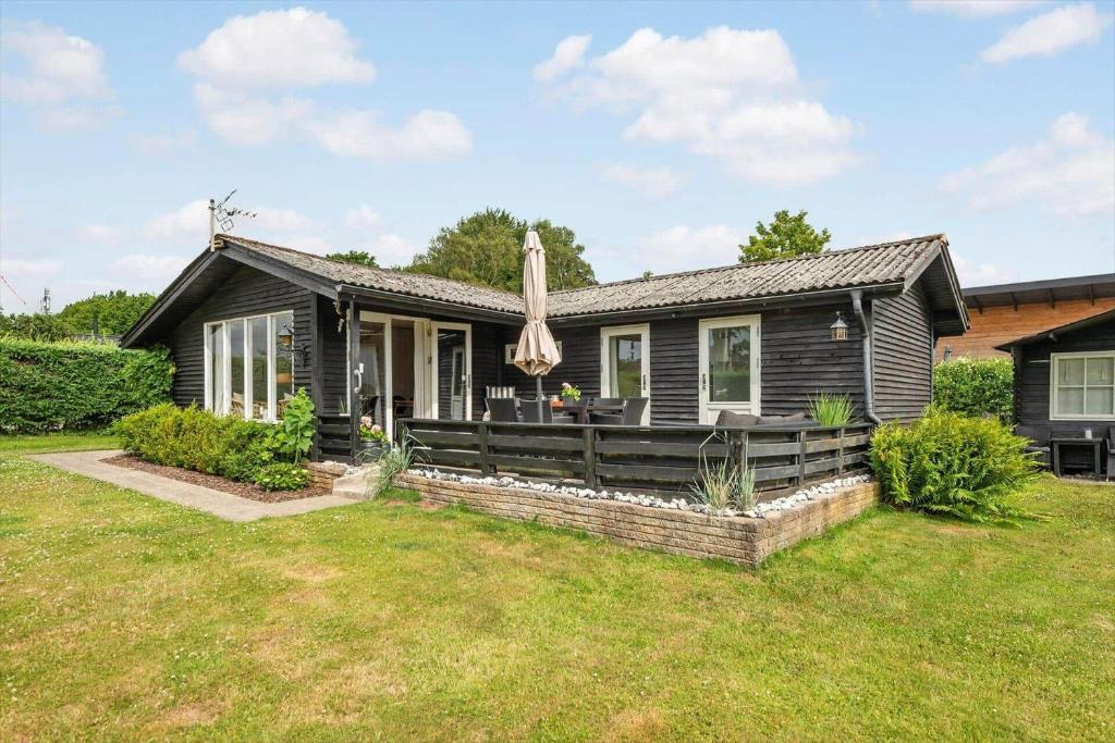 a black house with an umbrella in the yard at 30401-Odder-Stakket-Torn-12 in Odder