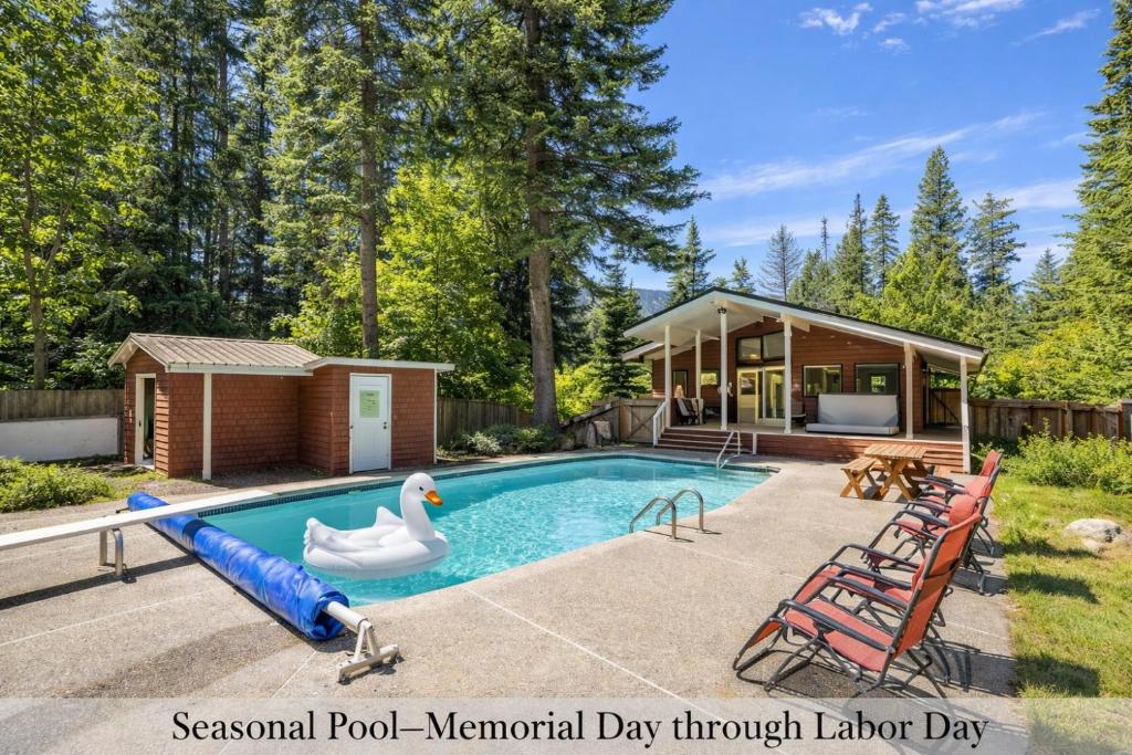 a swimming pool with a swan and a house at Maple Leaf Lodge by NW Comfy Cabins in Leavenworth