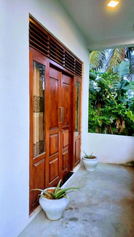 an entrance to a house with two plants in front of a door at Ahangama Wave Nook in Ahangama