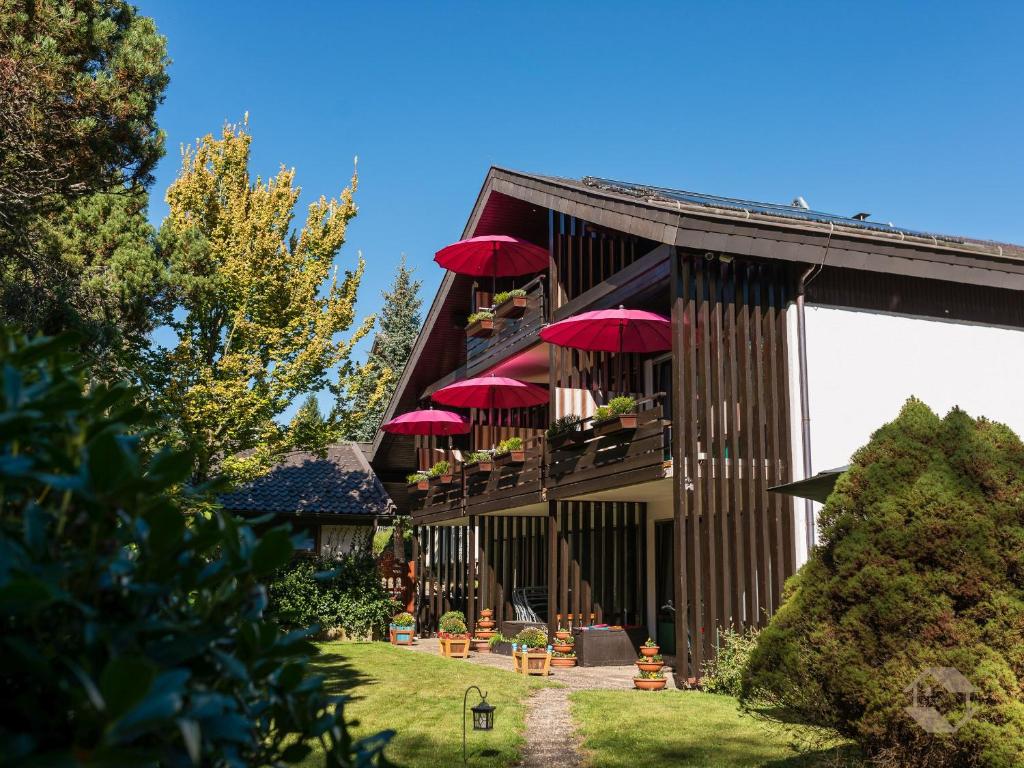 a building with red umbrellas on the balcony at Landhaus Gruden Sommerberg in Bad Wildbad