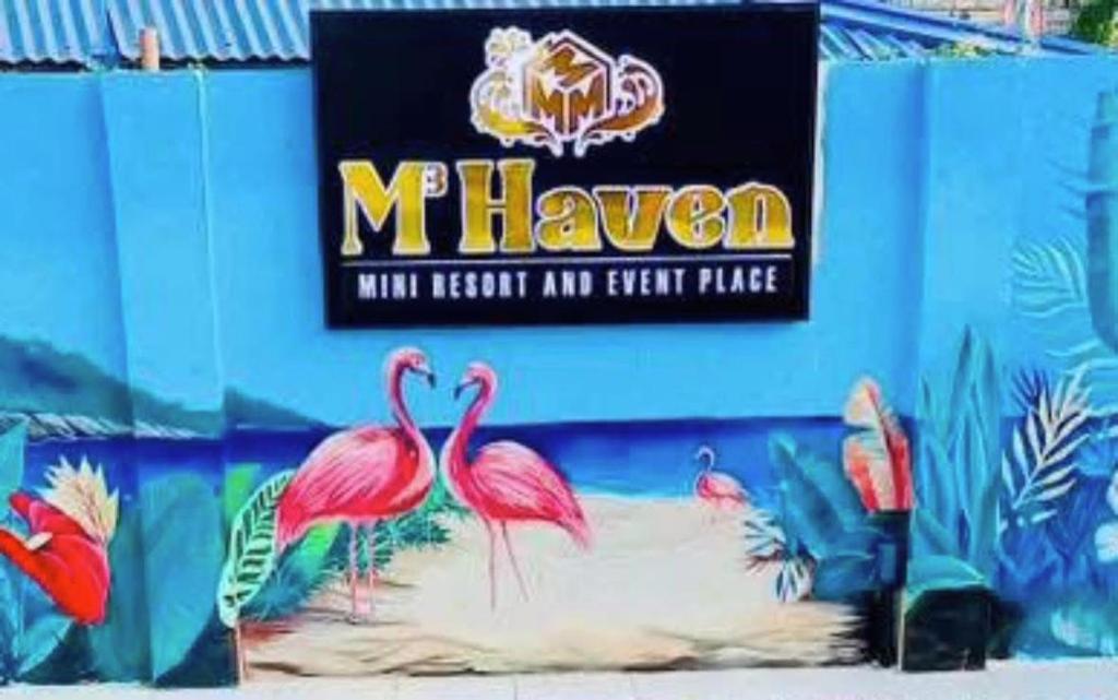 a sign on the side of a building with flamingos at M3 Haven Masbate in Masbate