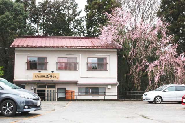 a white building with a red roof and two parked cars at ゲストハウスkaminn in Yoshino