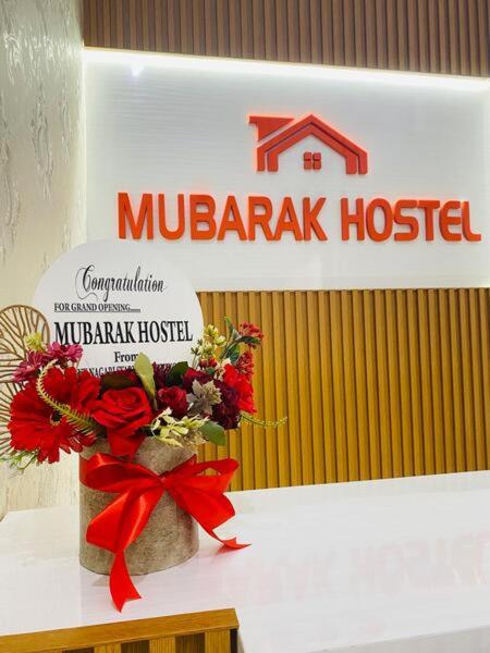 a sign for a mubarak hospital with a vase of flowers at Mubarak Hostel Syari'ah in Bukittinggi