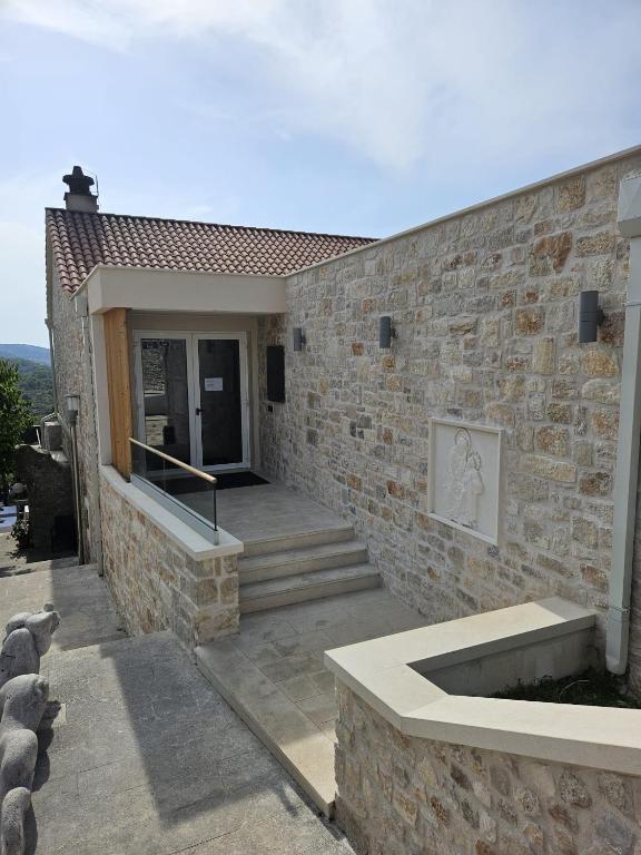 a brick building with a stone wall and a door at Hotel Sveta Ana in Donji Humac