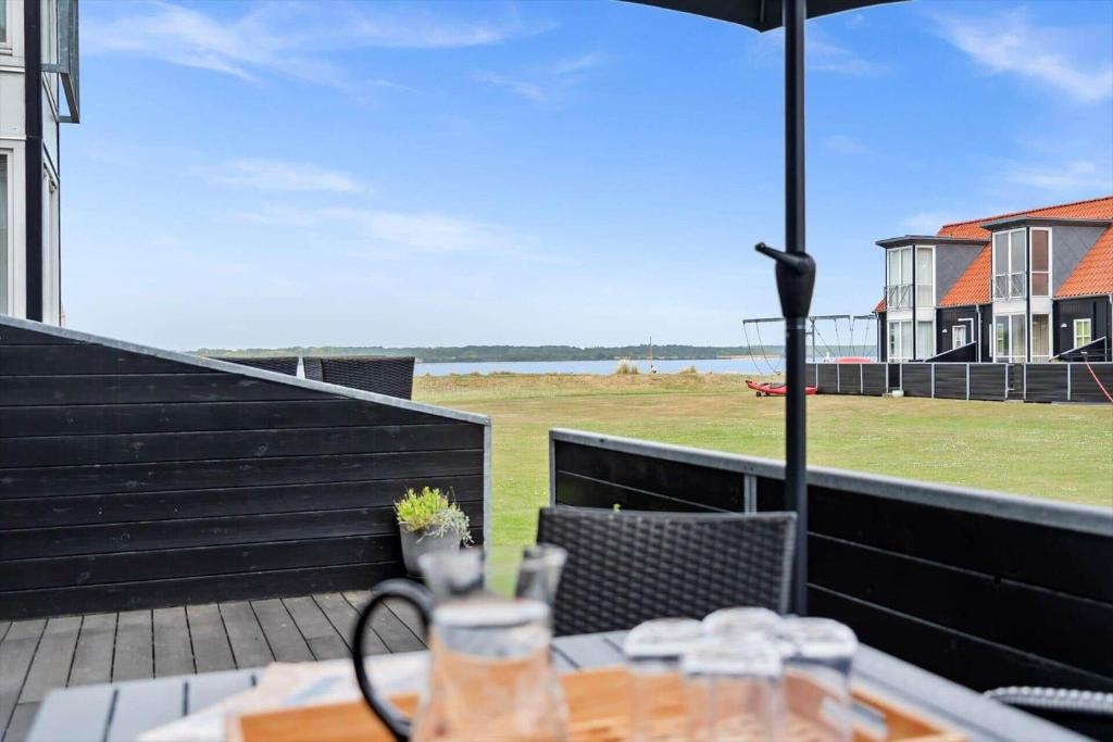 a patio with a table and an umbrella and a field at 40172-Juelsminde-Strandengen-30 in Juelsminde