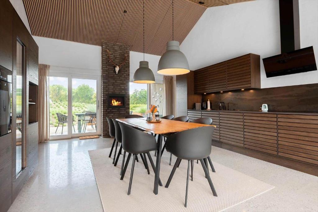 a kitchen with a wooden table and black chairs at 30477-Odder-Strandvaenget-2 in Odder