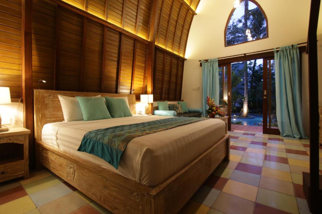 a bedroom with a large bed in a room at Green Bird Villa - CHSE Certified in Ubud