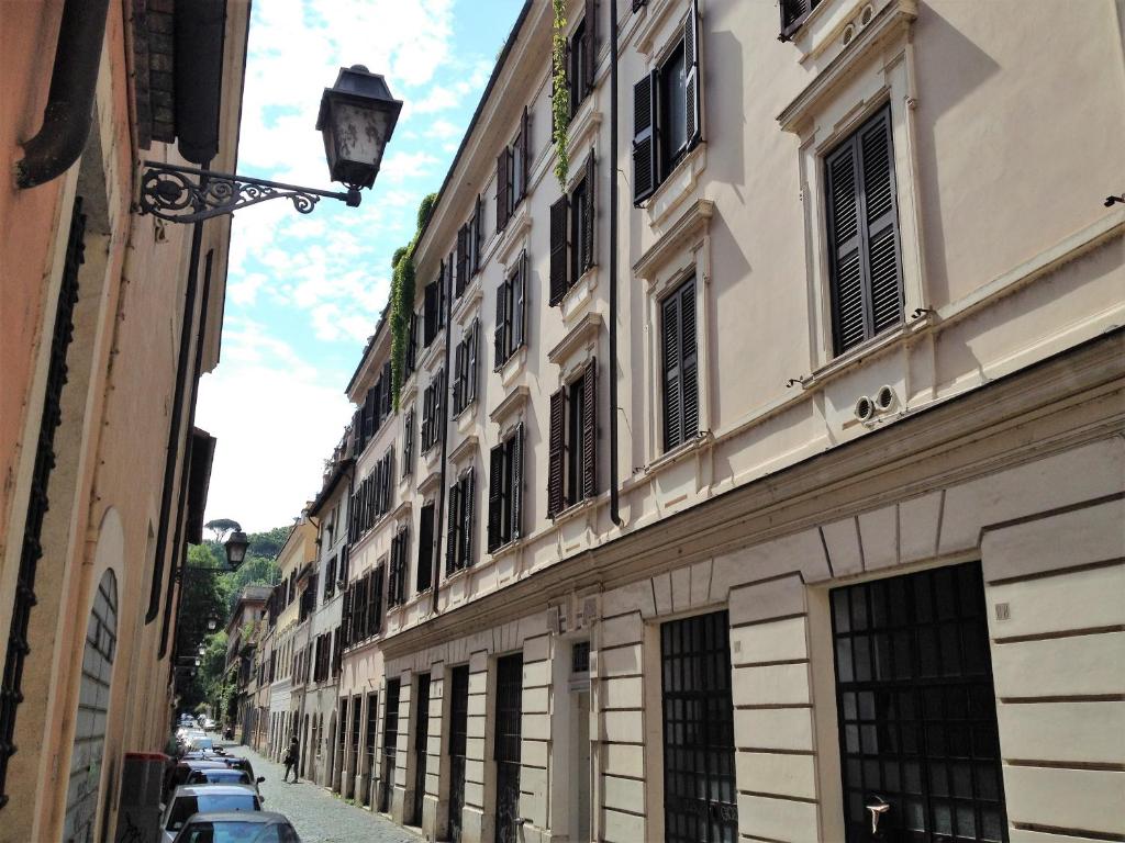 una calle con edificios y coches estacionados en la calle en Casa in Trastevere, en Roma